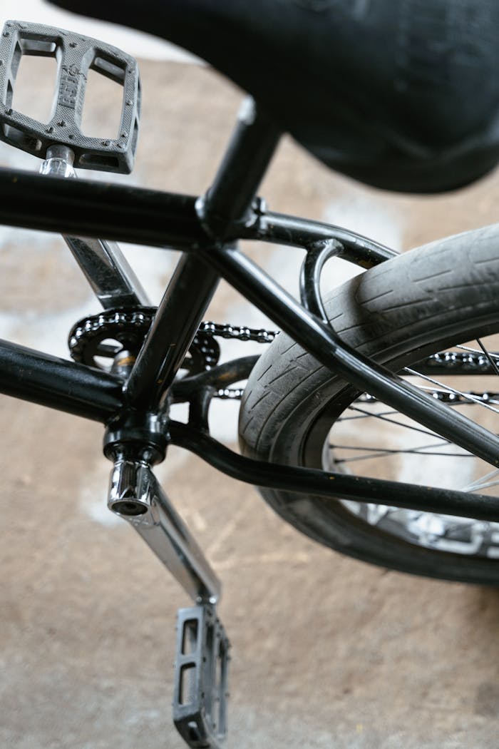 About Detailed view of a black bicycle frame, pedals, and tire showcasing sleek design.